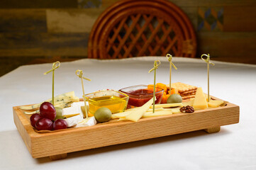 various types of cheese on wooden cutting board,