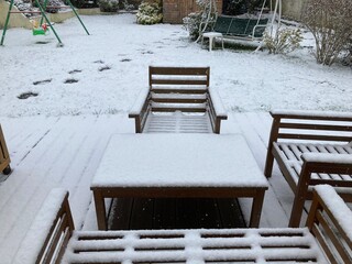chairs and tables in a snowy garden 