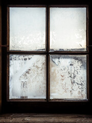 Wooden windows with frozen glass where there is a view to the outside when a sunny day