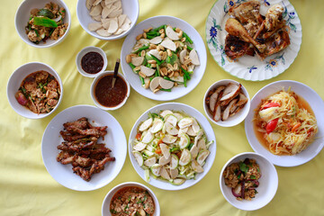 Fototapeta na wymiar Asian Local and Thai Traditional Food. North-East Style, Sticky rice, Grilled Chicken, Papaya Salad and Grilled Pork with Thai Spicy Sauce.