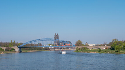 Fototapeta na wymiar Panoramic view over downtown of Magdeburg, old town, Elbe river, bridges and Magnificent Cathedral at early Spring, Germany, at sunny day and clear blue sky with a tour boat.