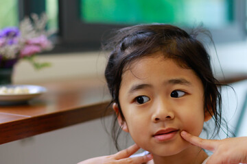 A Lovely Little Asian Girl Happy to Eating Homemade Cookies made at House.