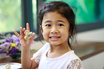 A Lovely Little Asian Girl Happy to Eating Homemade Cookies made at House.