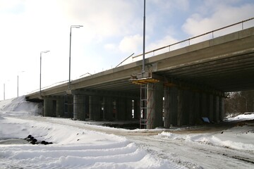 Landscape with a road bridge under construction in winter.