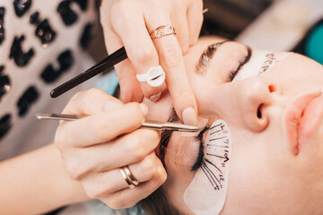 Cosmetic procedure for the extension of artificial eyelashes - the master glues the bundles