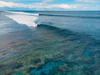 Blue barrel wave in tropical ocean. Aerial view of surfing barrel waves