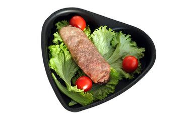 Baked turkey roll with lettuce and cherry tomatoes in a heart-shaped baking dish. Diet homemade dish.