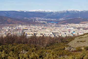 View from the mountain to the city of Magadan. A large city in a valley among the mountains. Beautiful autumn cityscape. Street and building view. Magadan, Magadan region, Siberia, Russian Far East.