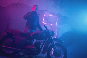Plakat Motor biker in the neon lights on the old brick wall background.