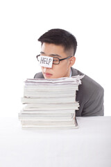 Portrait of young bisinessman leaning on stack of files 