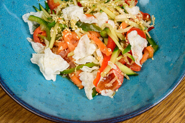 Vegetable vegetarian salad with tomatoes, peppers and onions on wooden table.