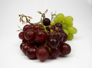 Fresh red and green grapes isolated on white background. Selective focus on the fresh red and green grapes.