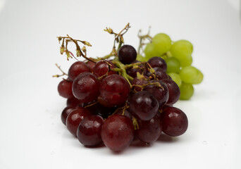 Fresh red and green grapes isolated on white background. Selective focus on the fresh red and green grapes.