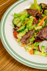 Fried meat with vegetables. Salad with meat, tomatoes, peppers, cucumbers and salad