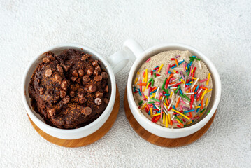 Two mug cakes, light and dark, stands together on a table