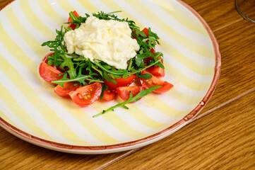 Spring vegetable salad with tomatoes on white plate