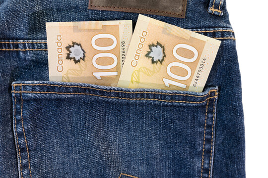 Money In Pocket. Canadian Money Currency One Hundred Dollar Paper Bills In A Jeans Pocket Isolated On White Background. Saving And Spending Concept