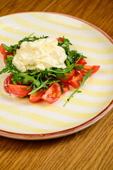 Spring vegetable salad with tomatoes on white plate