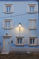 Fototapeta na wymiar Background from the facade of a modern blue building with an antique lantern. Piran, Slovenia. 