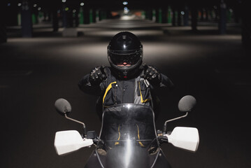 Motor biker is showing ahead by his index finger close up.