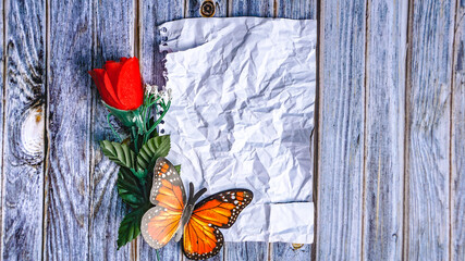 crumpled blank paper with rose flowers on wooden background with copy space for design, text. Valentine and love concept