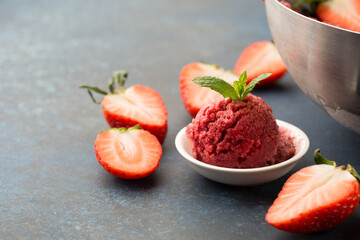 Homemade Fruit strawberry sorbet with mint in a bowl on wooden background.