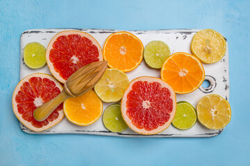 Fresh various citrus fruits on a blue background, top view