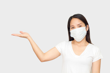 Young woman wearing medical mask standing over isolated white background smiling cheerful presenting with palm of hand looking at the camera