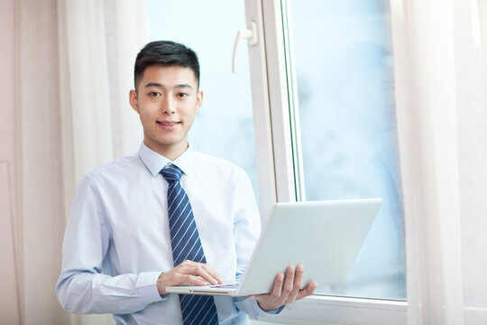 Portrait of young bisiness man with laptop