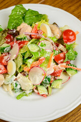 Vegetable vegetarian salad with tomatoes, peppers and onions on wooden table.