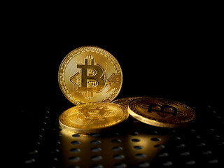 Close up of gold bitcoin on black background with selective focus