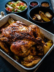 Whole roast chicken on plate on wooden table