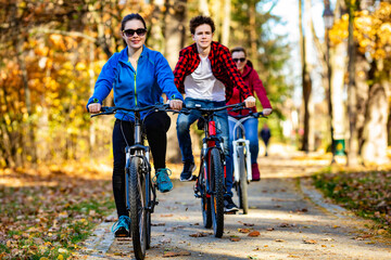 Healthy lifestyle - people riding bicycles in city park
