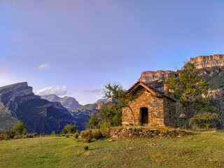 Fototapeta na wymiar Pequeña casa en lo alto de una montaña con fondo de montaña y cielo