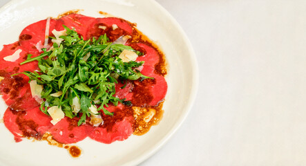 Vegetable vegetarian salad with tomatoes, peppers and onions on white table.