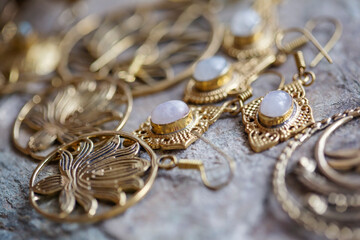 Brass jewelry with natural mineral gemstones on natural rocky background