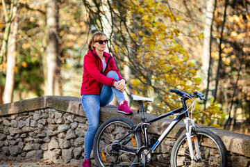 Fototapeta premium Woman resting with bike in park