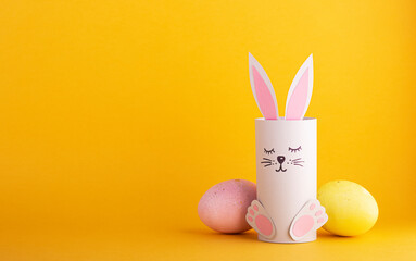 cute Easter bunnies made of paper with colorful Easter eggs