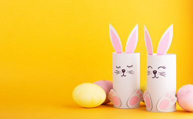cute Easter bunnies made of paper with colorful Easter eggs