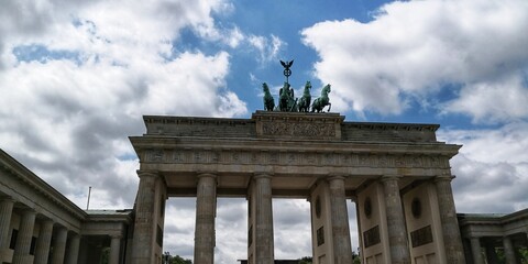 Fototapeta na wymiar Brandenburg Gate with quadriga against blue sky with clouds
