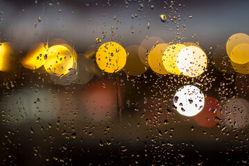 gotas de agua en un cristal con luces de fondo desenfocadas
