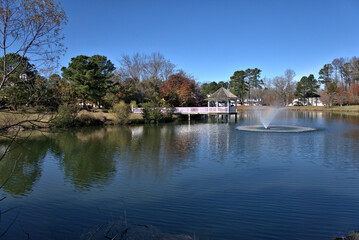 Fototapeta premium Fountain in a lake with a gazebo in the background