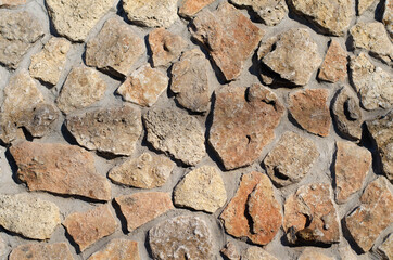 Obraz premium A wall of stones. Granite. Masonry. Clay tiles.