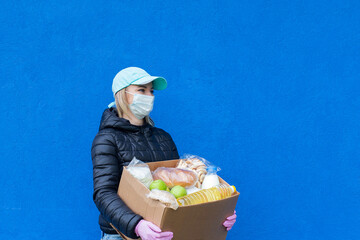 girl volunteer with charity box, on blue background