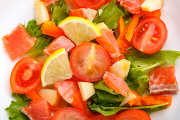 Salad with salmon and cherry tomatoes and lemon close-up.