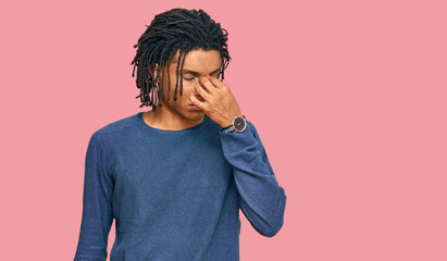 Young african american man wearing casual winter sweater tired rubbing nose and eyes feeling fatigue and headache. stress and frustration concept.