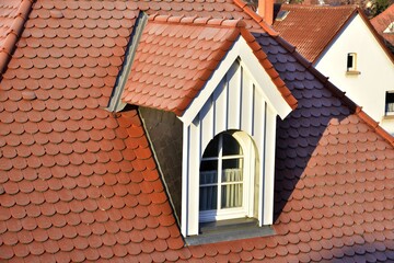 Obraz premium Renovierte Dachgauben mit Schiefer-Schindel-Verkleidung als Wetterschutz an einem denkmalgeschützten Wohngebäude