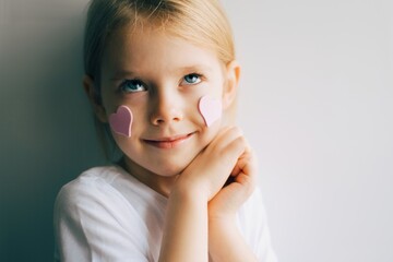 Lovely little girl with paper hearts. Valentines day. Portrait of a child holding pink valentine. - 406207326
