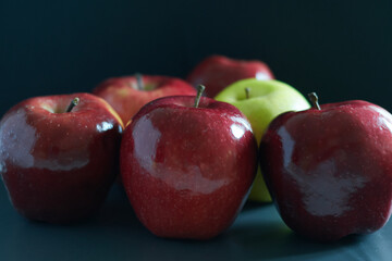 Bright red apples and a green apple