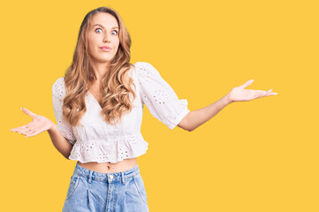 Young caucasian woman with blond hair wearing elegant summer tshirt clueless and confused...